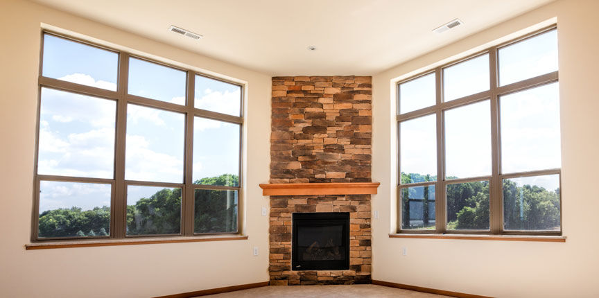 Apartment living room with corner fireplace and large windows